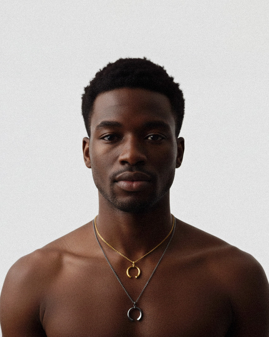 Man wearing gold necklaces on a plain background