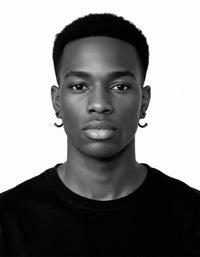 Black and white portrait of a person wearing earrings.